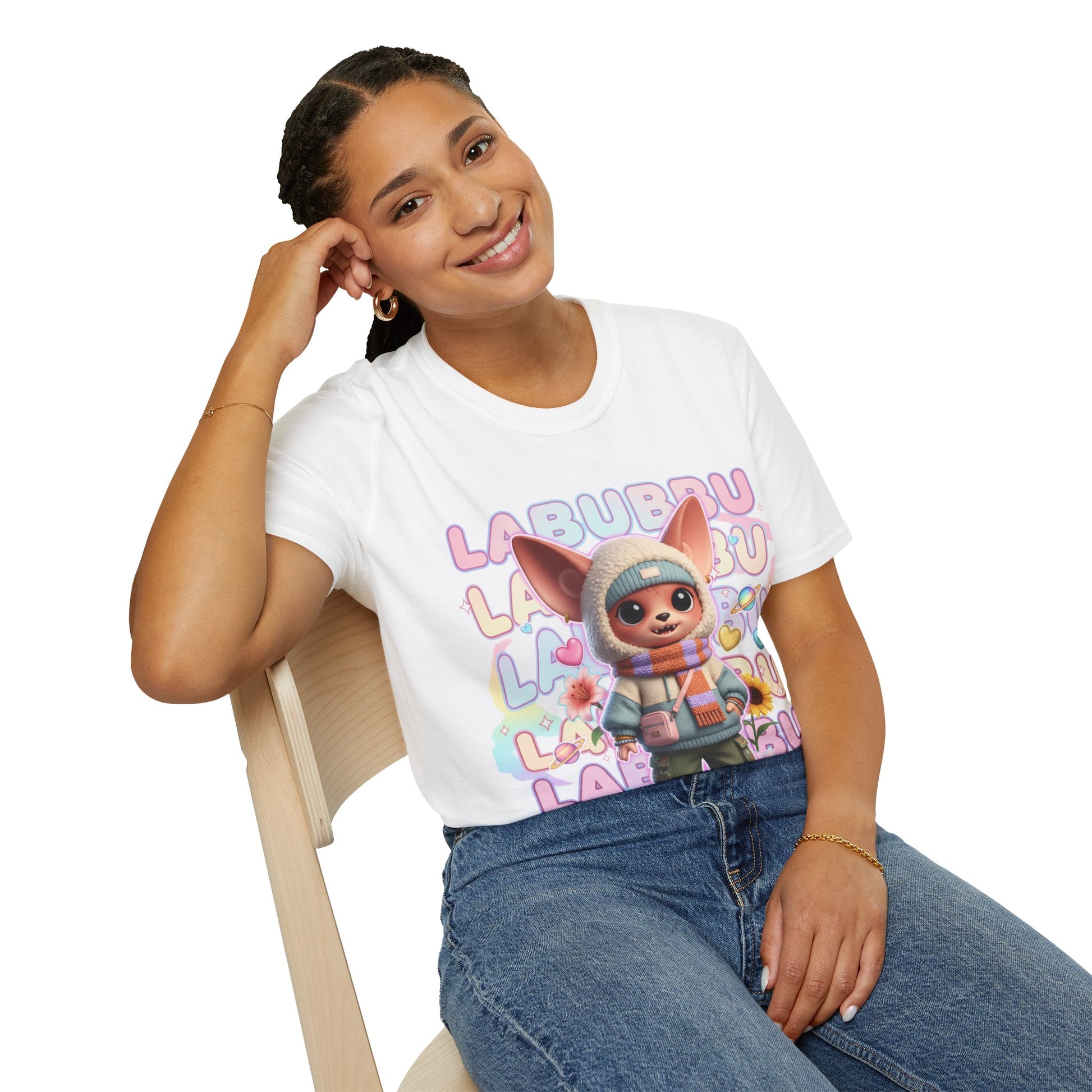 Person wearing a white t-shirt with a cartoon character and colorful text, sitting on a chair.